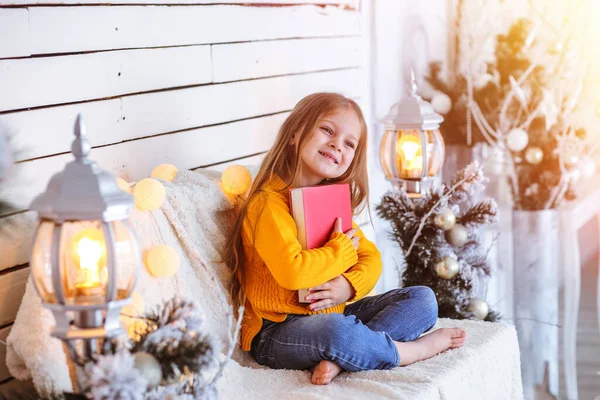 Menina com um livro sobre o fundo do fundo de Natal Fotos De Bancos De Imagens Sem Royalties