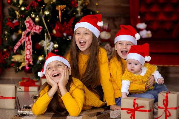 Niños sonriendo con sombreros rojos en el fondo de la Navidad Imagen de archivo