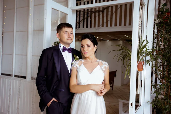 Krásná nevěsta v elegantních šatech s ženichem v obleku — Stock fotografie