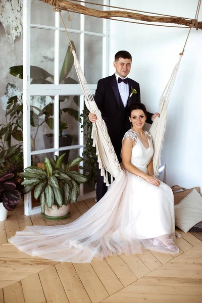 漂亮的新娘穿着雅致的衣服坐在吊床里。 — 图库照片