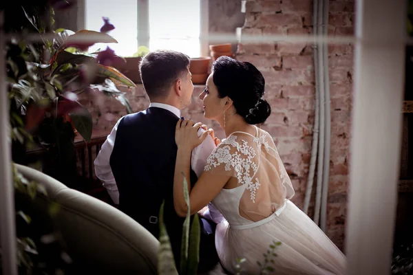 Brudgum i väst och vacker brud i en elegant klänning sitter ba — Stockfoto