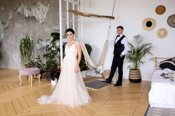 Mooie bruid in een elegante jurk en bruidegom in een vest in — Stockfoto
