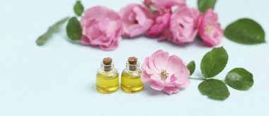 Mini şişelerde Rosehip kozmetik yağı ve pembe gül çiçeği. Rahatlama için spa tedavileri.