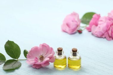 Mini şişelerde Rosehip kozmetik yağı ve pembe gül çiçeği. Rahatlama için spa tedavileri.