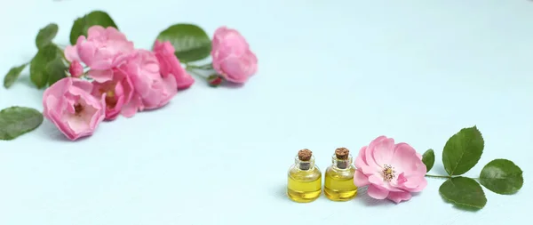 ミニボトルやピンクのバラの花にローズヒップ化粧品油 リラクゼーションのためのスパトリートメント ロイヤリティフリーのストック画像