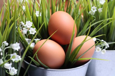 Siyah desenli arka planda çimenlerin arasında paskalya yumurtaları.
