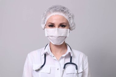 Koruyucu tıbbi maskeli bir kadın doktor. Salgın virüsü COVID-19