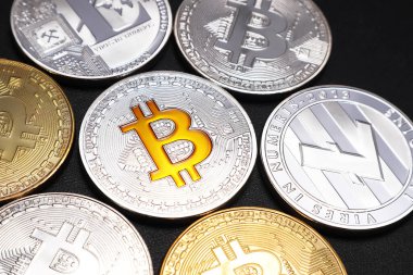 Siyah desenli arka planda Bitcoin ve Litecoin sikkeleri