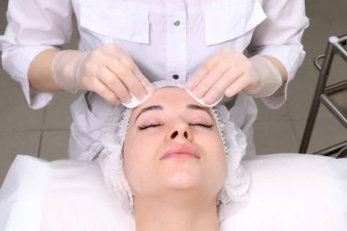 Güzellik uzmanı arınma prosedürünü genç ve güzel bir hasta kız haline getiriyor. Yüz ve vücut bakımı kavramı