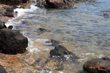 Deniz kenarında siyah volkanik taşların