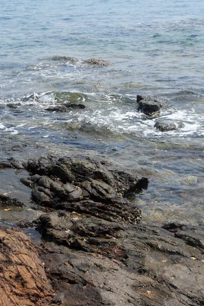 Чорні камені вулканічних біля моря — стокове фото