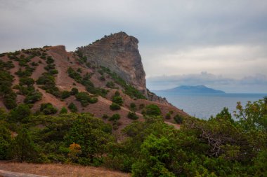 Dağları ve denizi olan güzel bir manzara.