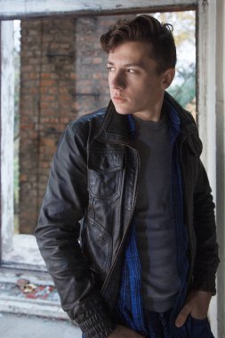 eski püskü duvar arasında bir deri ceketli bir çocuk portresi