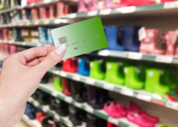 Herbstschuhe Kaufen Weibliche Hand Hält Eine Bankkarte Auf Gummistiefeln — Stockfoto