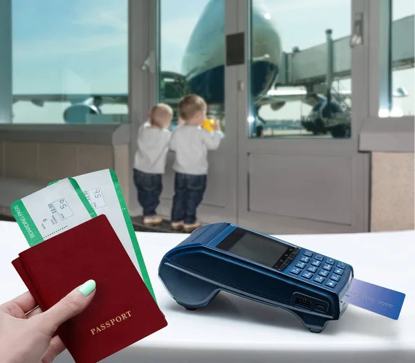 Buying plane tickets. Modern payment blue terminal and card. Kids dream of traveling, looking at the plane.