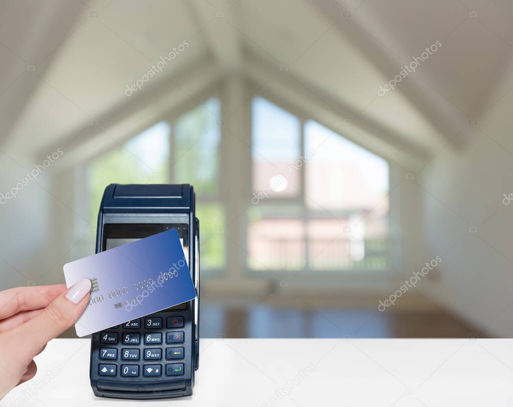 Payment for real estate purchase with a bank card with a modern payment terminal.