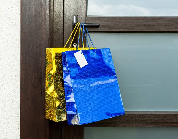 礼品袋挂在前门的把手上 信使在入口处留下了一份网上订购单 预防措施 不可接触的交付 — 图库照片