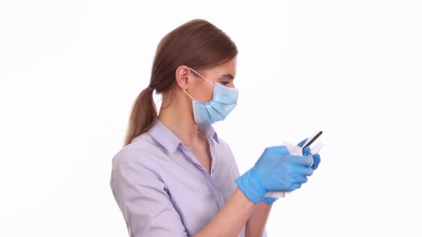 Jovem mulher desinfectando smartphone com spray anti-séptico — Vídeo de Stock