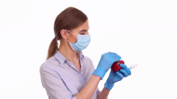 Mujer joven desinfectando fruta de manzana roja con spray antiséptico — Vídeos de Stock