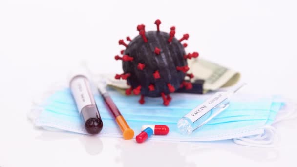 COVID-19 coronavirus medical concept still life with vaccine, money, blood test, syringe and sterile mask rotating — Stock Video