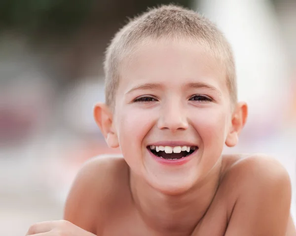 Beau garçon souriant enfant prenant un bain de soleil — Photo