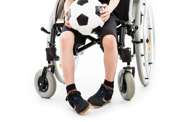 Postižené dítě chlapec sedí na vozíku drží fotbalový míč — Stock fotografie