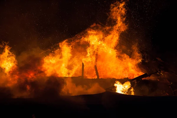 Queimando chama de fogo no telhado da casa de madeira — Fotografia de Stock