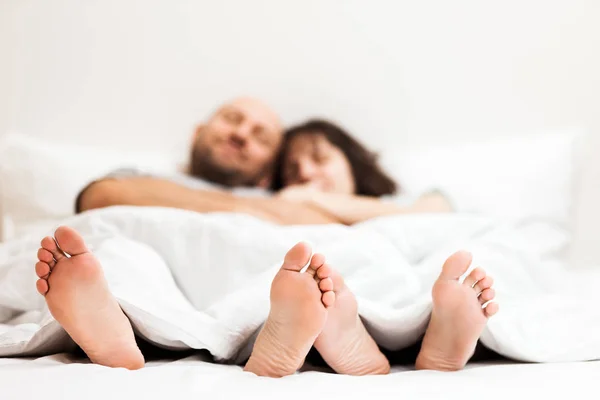 Loving caucasian couple in relationship lying and hugging on bed — Stock Photo, Image