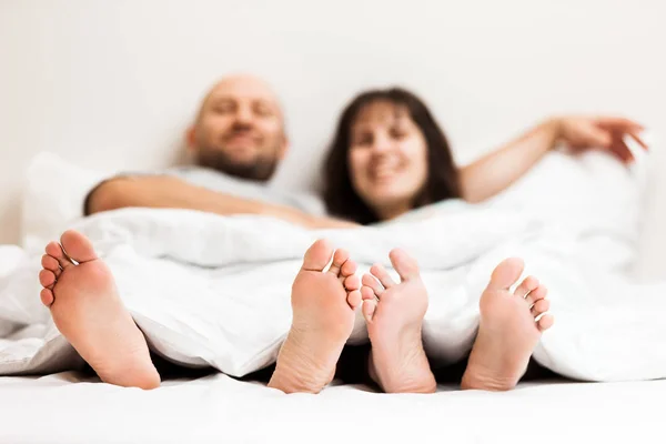 Loving caucasian couple in relationship lying and hugging on bed — Stock Photo, Image
