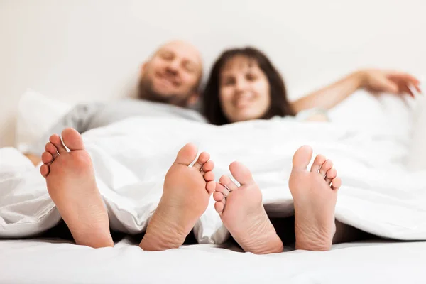 Loving caucasian couple in relationship lying and hugging on bed — Stock Photo, Image