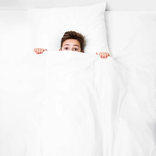 Peeking child boy lying bed covering face with blanket — Stock Photo, Image