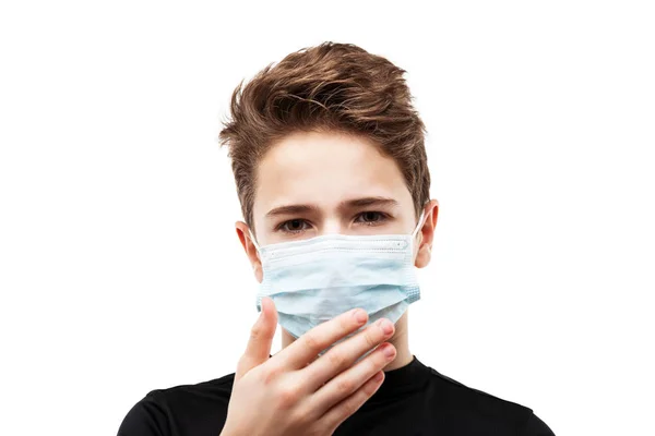 人間の人口ウイルス 感染症 インフルエンザの病気の予防と産業排気ガスの保護の概念 10代の男の子が呼吸器保護医療マスクの手を身に着けて白い孤立顔を隠す ロイヤリティフリーのストック画像
