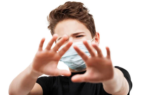 人間の人口ウイルス 感染症 インフルエンザの病気の予防と産業排気ガスの保護の概念 10代の男の子が呼吸器保護医療マスクの手を身に着けて白い孤立顔を隠す ストック画像