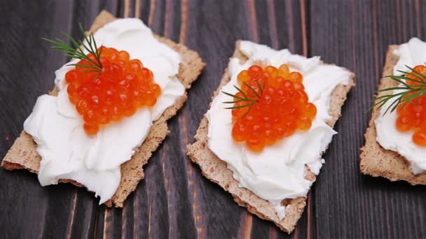 Bolachas com queijo creme e caviar vermelho close-up — Vídeo de Stock