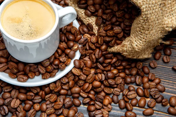 Cup of coffee and beans on wooden background — Stock Photo, Image