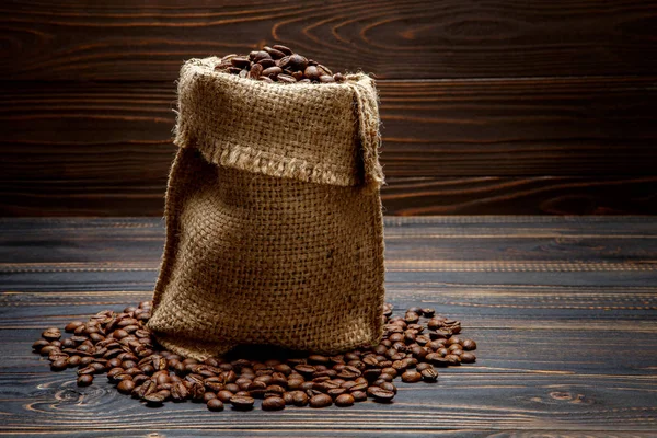 Pražená kávová zrna na dřevěném pozadí — Stock fotografie