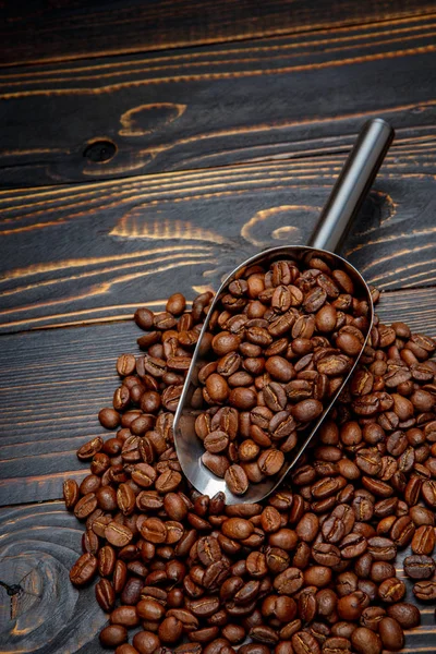 Pražená kávová zrna na dřevěném pozadí — Stock fotografie