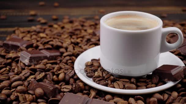 一杯のコーヒーと木製の背景に豆の焙煎 — ストック動画