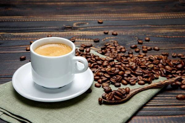 Palone ziarna kawy i filiżanki na podłoże drewniane — Zdjęcie stockowe