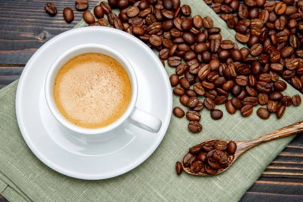 Roasted coffee beans and cup on wooden background Stock Image