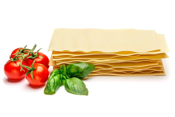 Hojas secas de pasta de lasaña y tomate sin cocer —  Fotos de Stock