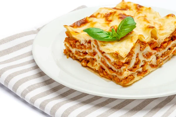 Gedeelte van smakelijke lasagne op wit wordt geïsoleerd — Stockfoto