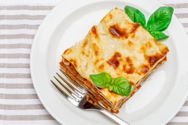 Portion de lasagnes savoureuses isolées sur blanc — Photo