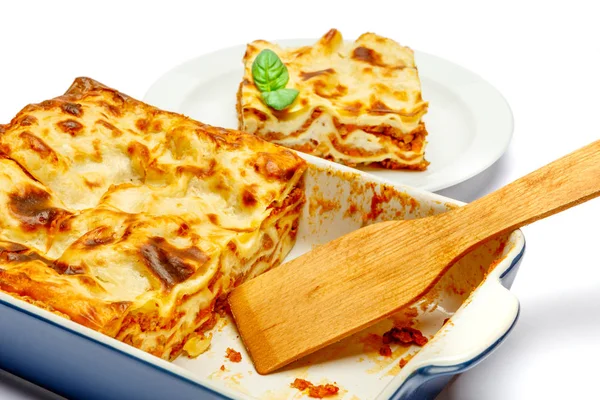 Gedeelte van smakelijke lasagne op wit wordt geïsoleerd — Stockfoto