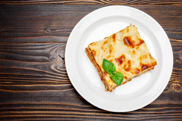 Portion leckere Lasagne auf Holzboden — Stockfoto