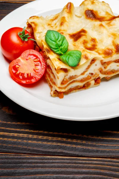 Gedeelte van smakelijke lasagne op houten achtergrondkleur — Stockfoto