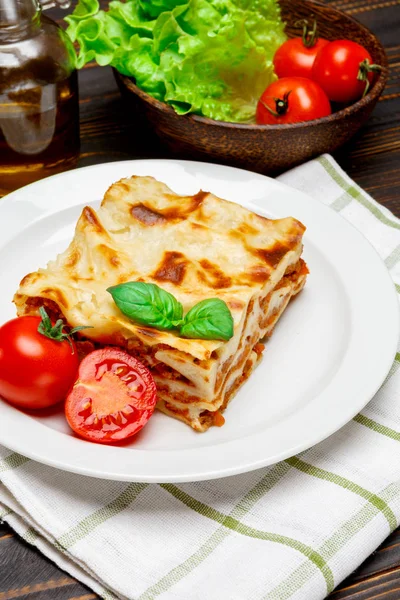 Část chutné lasagne na dřevěné pozadí — Stock fotografie