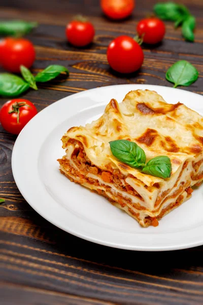 Portion of tasty lasagna on wooden backgound — Stock Photo, Image