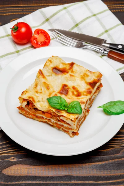 Del av välsmakande lasagne på trä backgound — Stockfoto