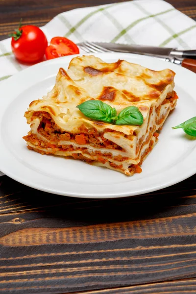 Část chutné lasagne na dřevěné pozadí — Stock fotografie